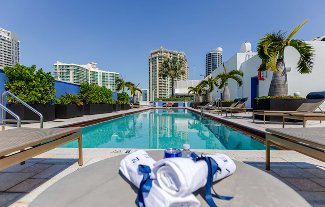 a swimming pool with palm trees and buildings in the background