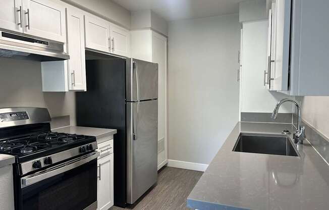 A kitchen with a black stove top oven and a black refrigerator.
