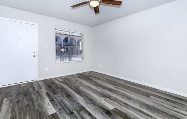 a living room with hardwood floors and a ceiling fan