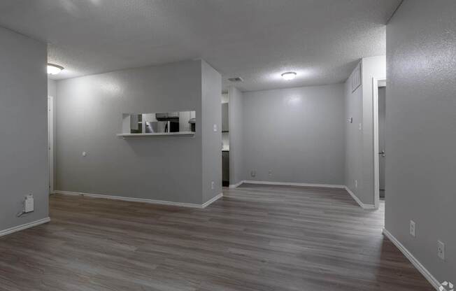 A room with a grey wall and a wooden floor.