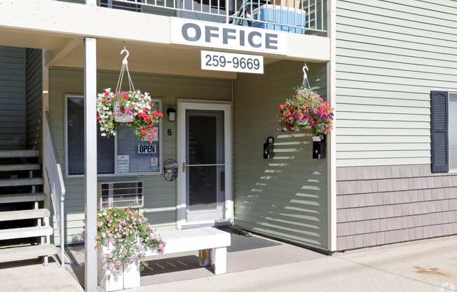 the front of an office building with flowers on the front porch