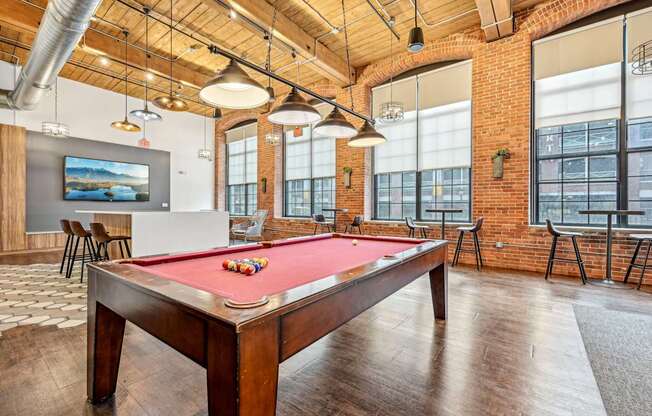 a pool table in an office space with a red pool table