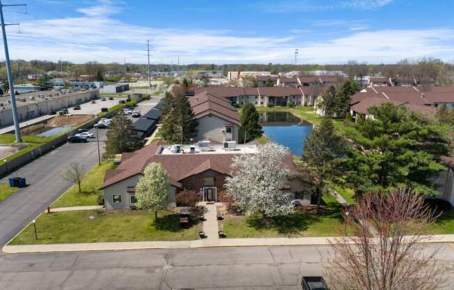 an aerial view of a neighborhood with a pond and houses