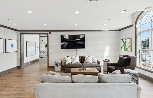 a living room with a large couch and a tv on the wall