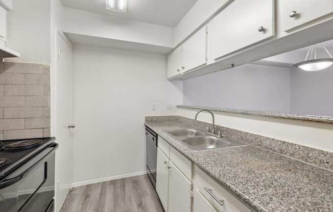 the kitchen has granite counter tops and a stainless steel sink