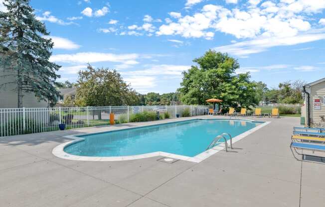 a swimming pool with a fence and trees in the background