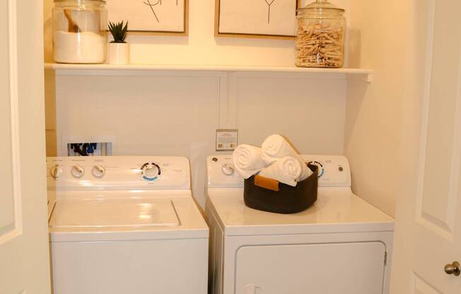 A small bathroom with a white sink and a white dryer.