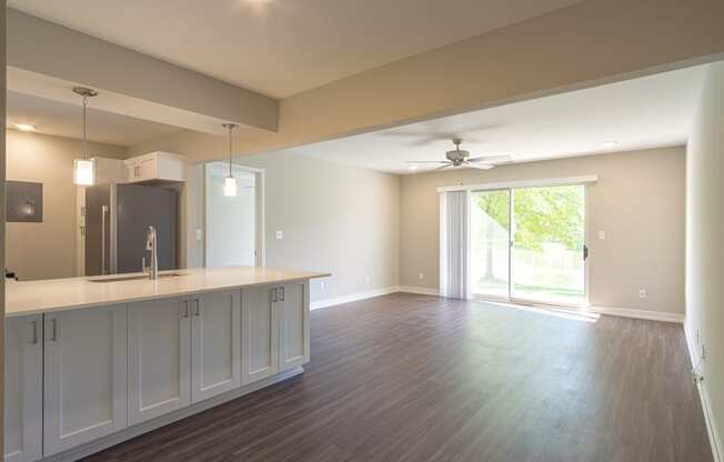 a kitchen and living room with a sliding glass door leading to a patio