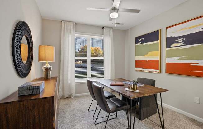 Flatiron West Trade Apartments staged model unit home office with gray carpet and dark wood furniture