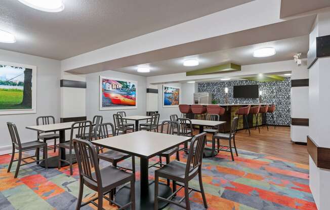 a dining room with tables and chairs and a bar