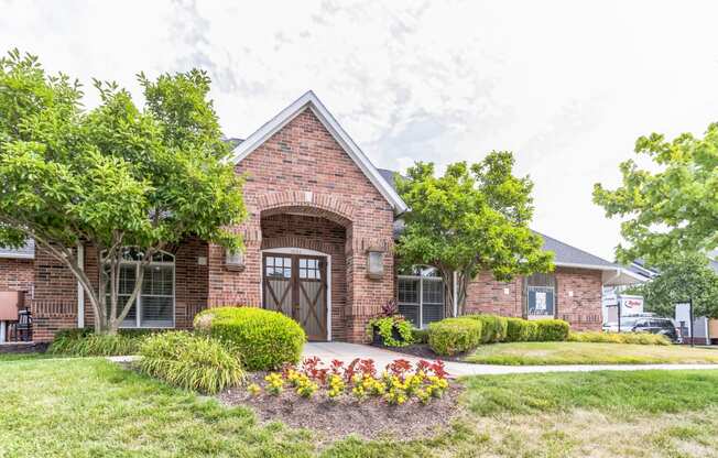 the front of a brick house with a driveway and a garage door