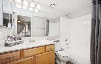 A white bathroom with a toilet, sink, and mirror.
