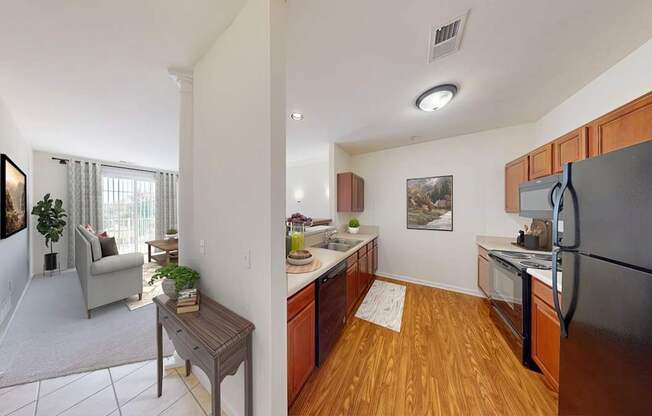 A kitchen with wooden floors and a black refrigerator.