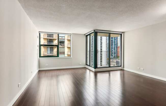 an empty living room with wood flooring and a large window