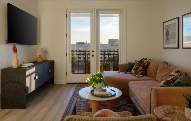 Natural light, warm finishes, and a private balcony view create a living space that feels both refined and inviting.