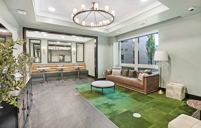 a living room with a green rug and a large chandelier