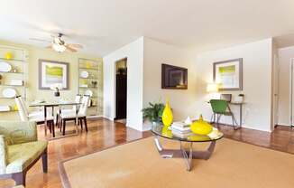 A living room with a yellow coffee table and green chairs.