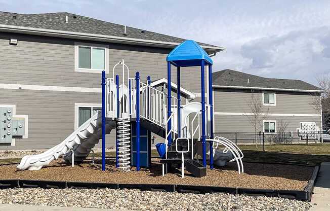 A playground with a blue structure and a slide.