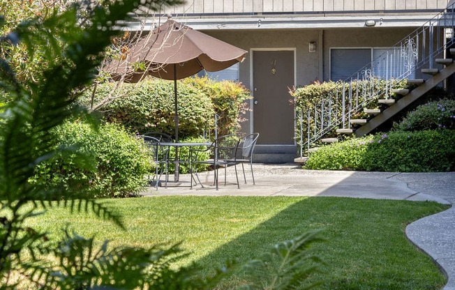 a patio with an umbrella in front of a house