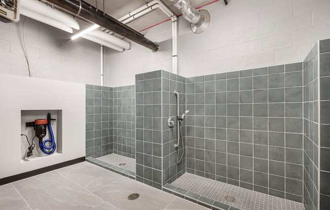 a shower in a room with gray tiles