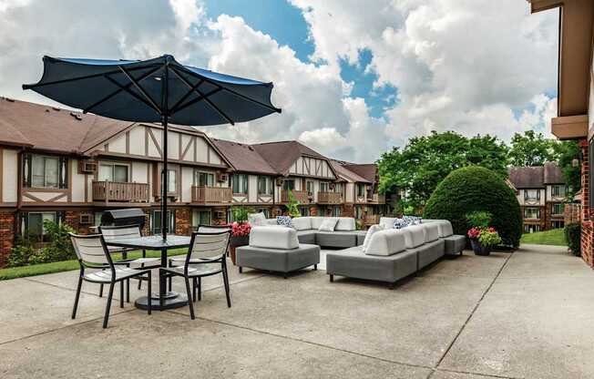 A patio with a table and chairs under an umbrella