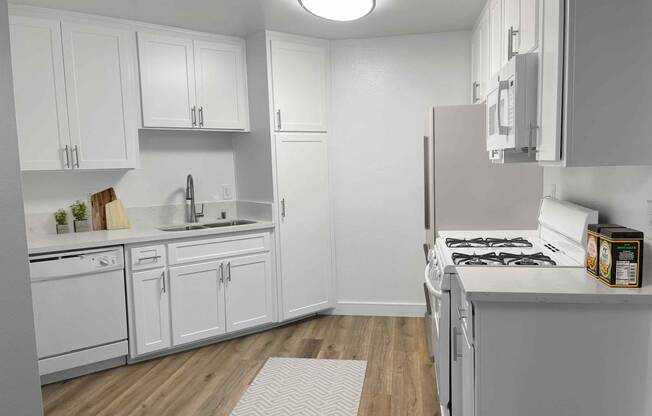 a kitchen with white cabinets and white appliances