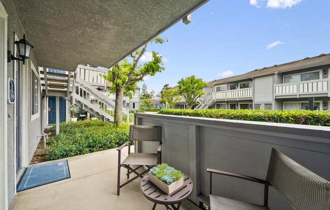 a balcony with two chairs and a table on a balcony