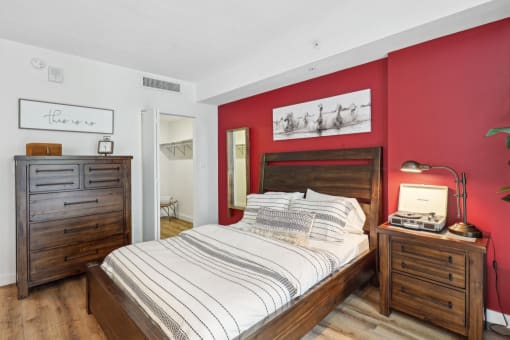 a bedroom with a bed and red walls and wooden furniture