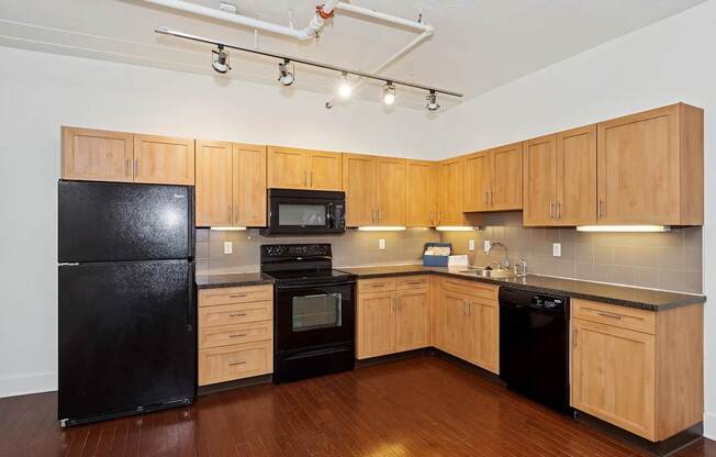 A kitchen with black appliances and wooden cabinets.