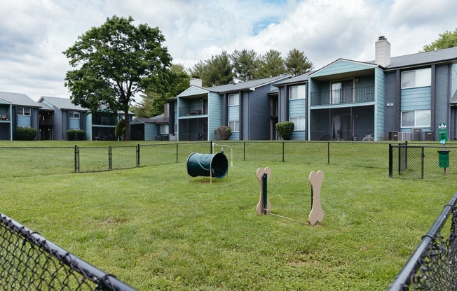 a group of apartment buildings with playground equipment in the grass