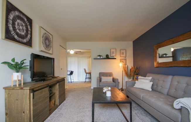 This is a photo of the living room of the 550 square foot 1 bedroom, 1 bath, balcony floor plan model apartment at College Woods Apartments in Cincinnati, OH.