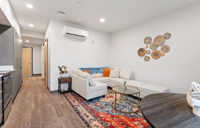A modern living room with a white couch and a rug on the floor.