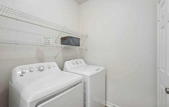 A white washing machine and dryer in a small laundry room.