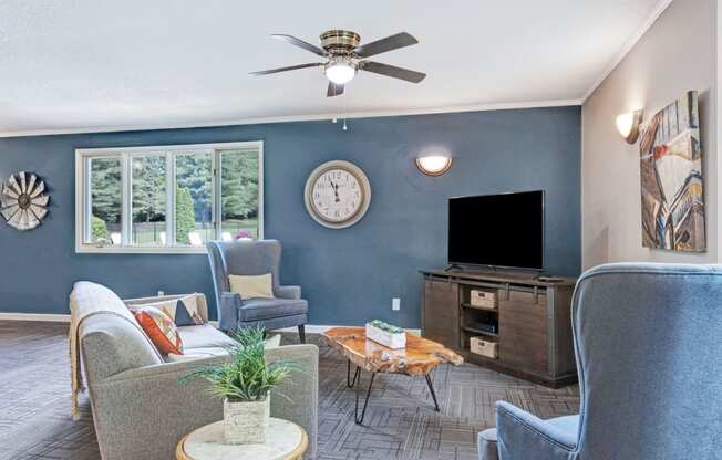 a living room with blue walls and a large clock on the wall