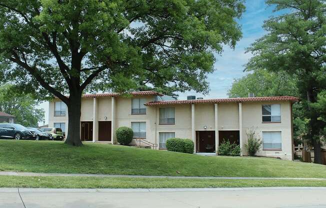 a large apartment complex with trees in front of it