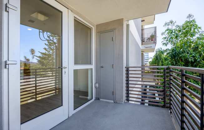 the entrance to a balcony of a condo with glass doors