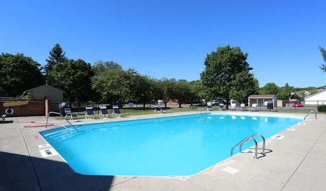a blue swimming pool with chairs around it