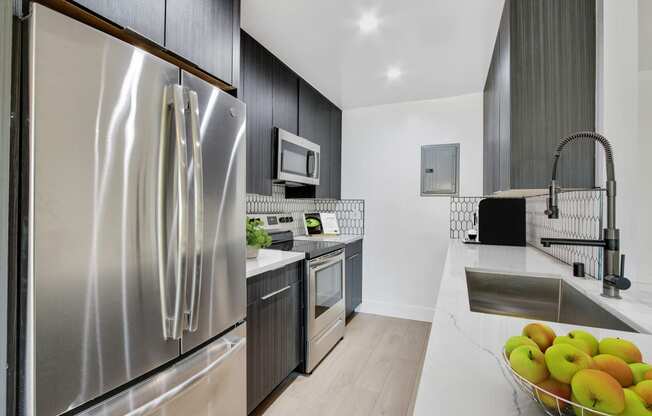 a kitchen with stainless steel appliances and a counter with a bowl of fruit