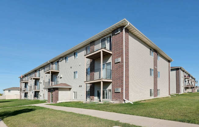 an apartment building with a sidewalk in front of it. Fargo, ND Country Edge Apartments