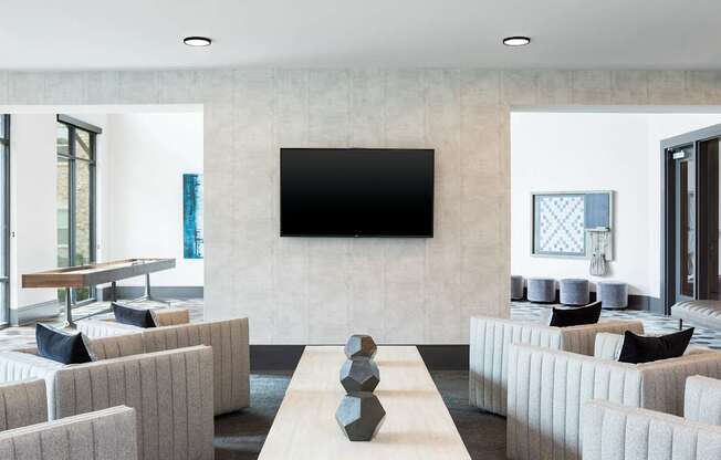 A modern living room with a large flat screen TV mounted on the wall.
