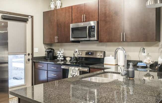 Interiors-Kitchen with dark cabinetry, modern hardware and granite countertops