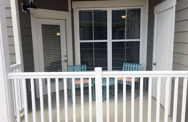 Patio with railing and door to storage.