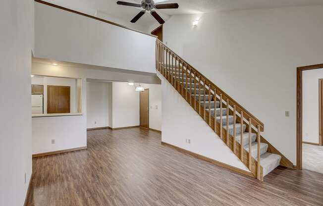 the living room and dining room of an empty house with a staircase