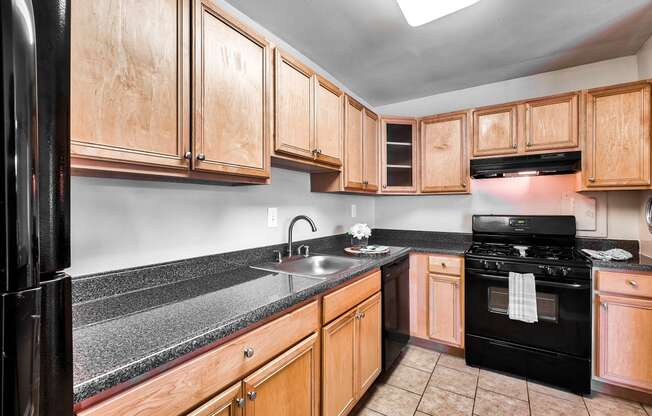 full kitchen with black appliances and granite counter tops and wood cabinets