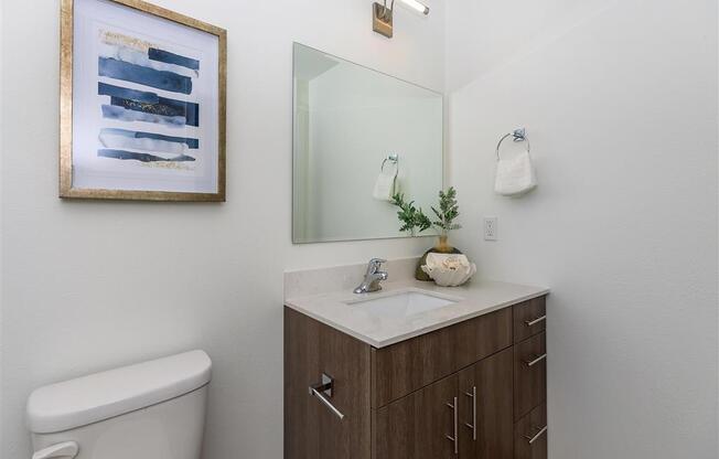 a bathroom with a toilet sink and mirror at Jefferson Yards, Tacoma, WA