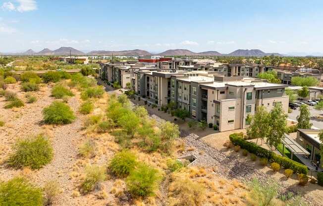 A desert landscape with apartment buildings in the foreground.