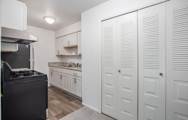 a kitchen with white cabinets and a large closet at Fairlane Apartments in Springfield, MI