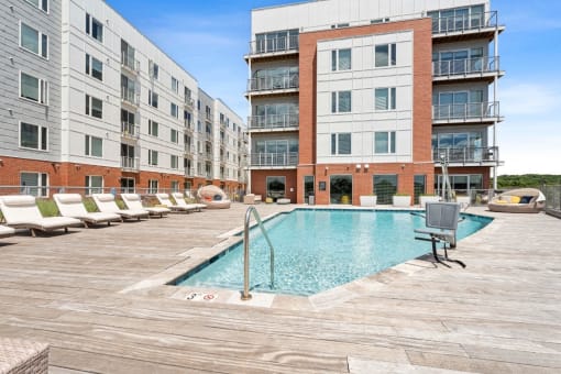 a swimming pool in front of an apartment building at The Waterford At Rocketts Landing Apartments, PRG Real Estate, Richmond, Virginia