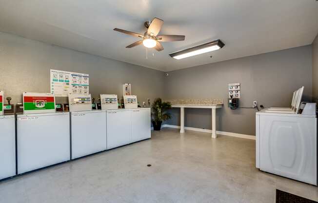 a laundry room with machines and a ceiling fan