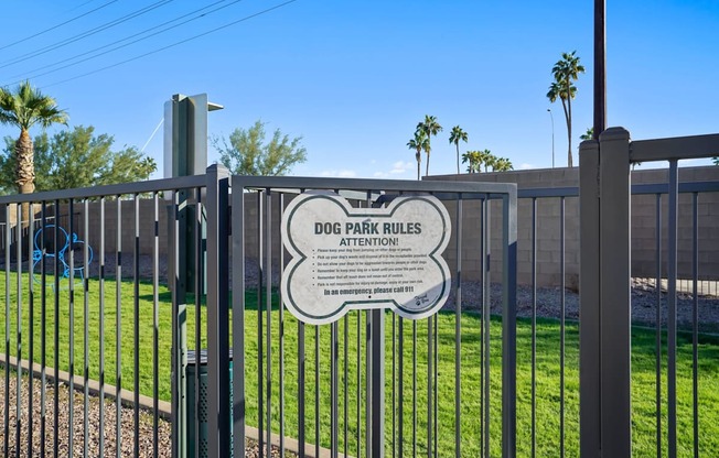 A sign on a fence that says Dog Park Rules Attention.